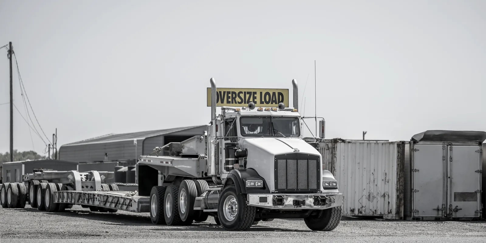 Oversize-load truck hauling steel building components — pickup and delivery minutes off Beltway 8, Houston