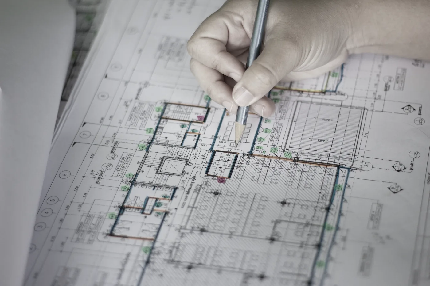 Engineer's hands over metal building blueprints — permit-ready drawings prepared overnight