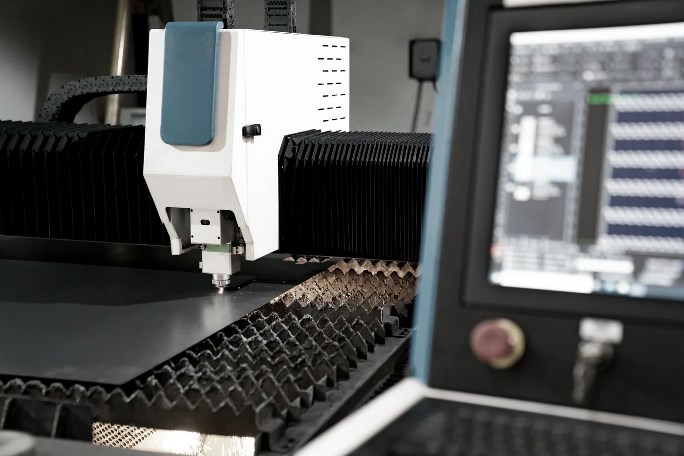 Laser cutting head slicing steel plate — the equipment class being commissioned in Houston