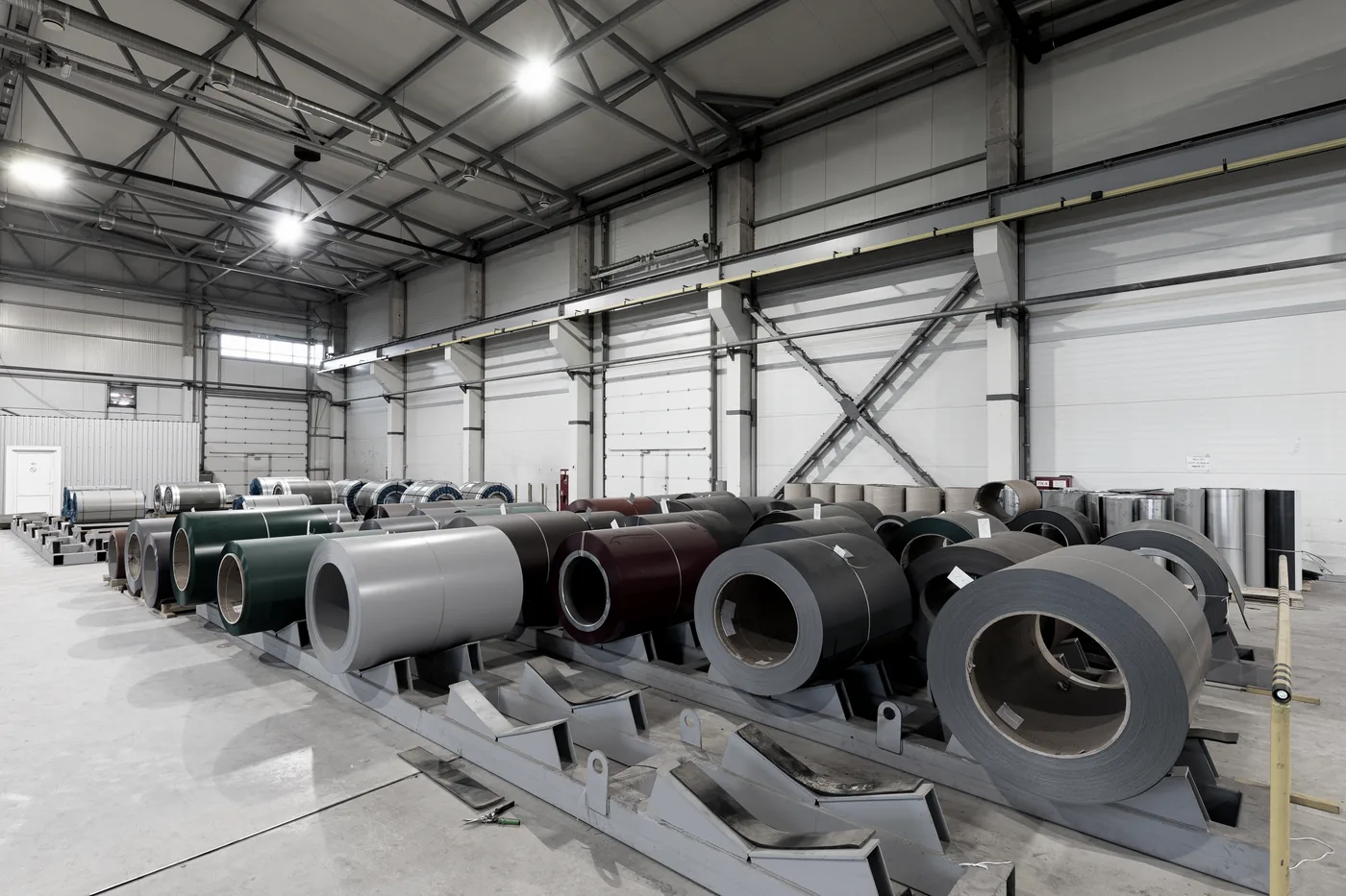 Steel coils staged at the PBR panel roll-forming line inside the metal building plant
