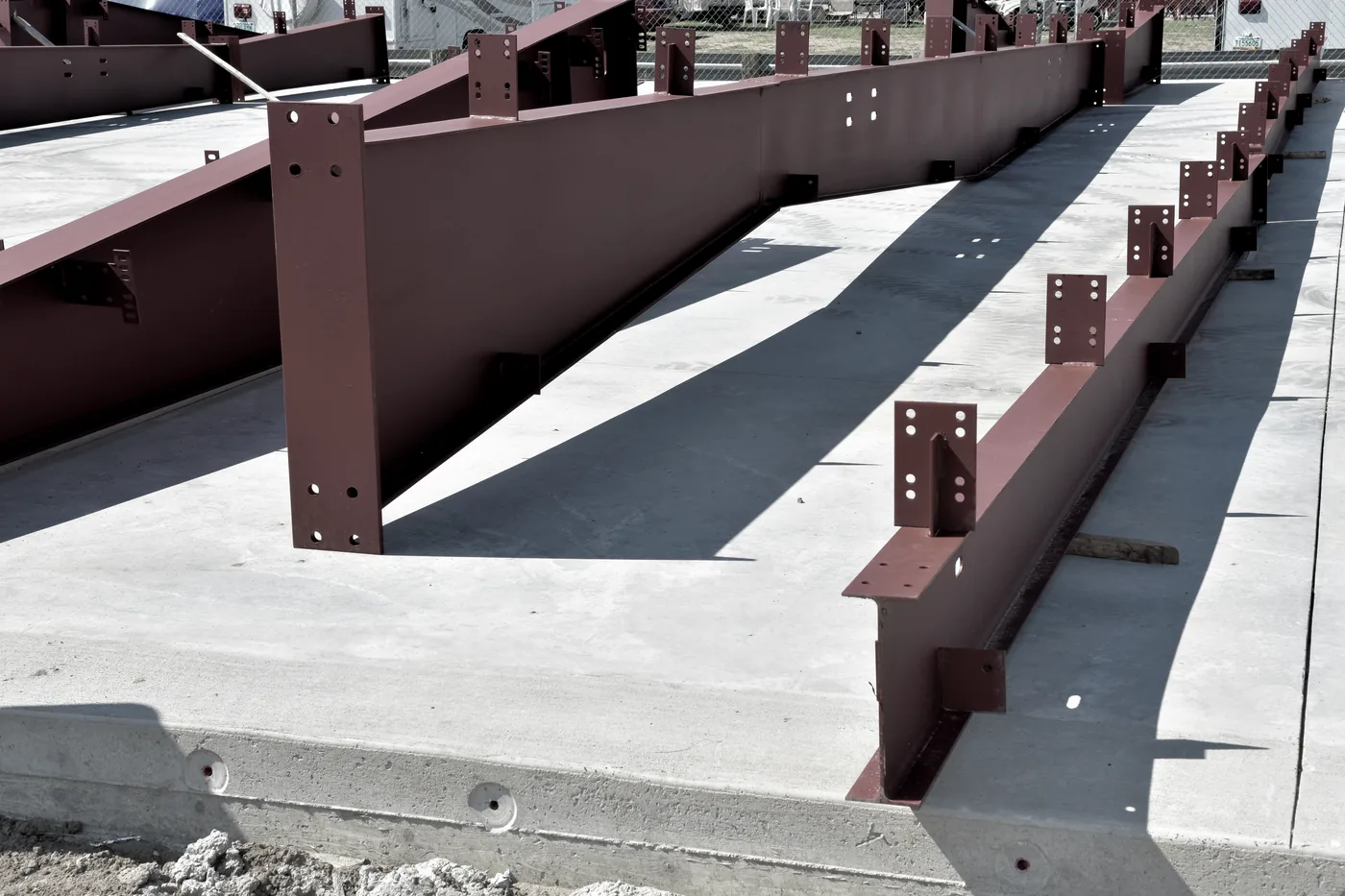 Fabricated red-primed steel I-beam frames — primary framing for metal buildings